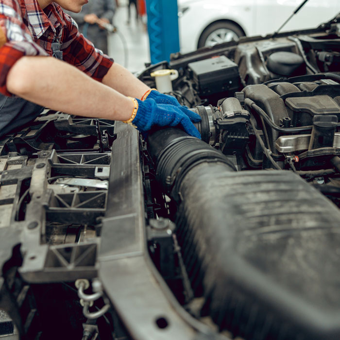 mechanic replacing a radiator hose
